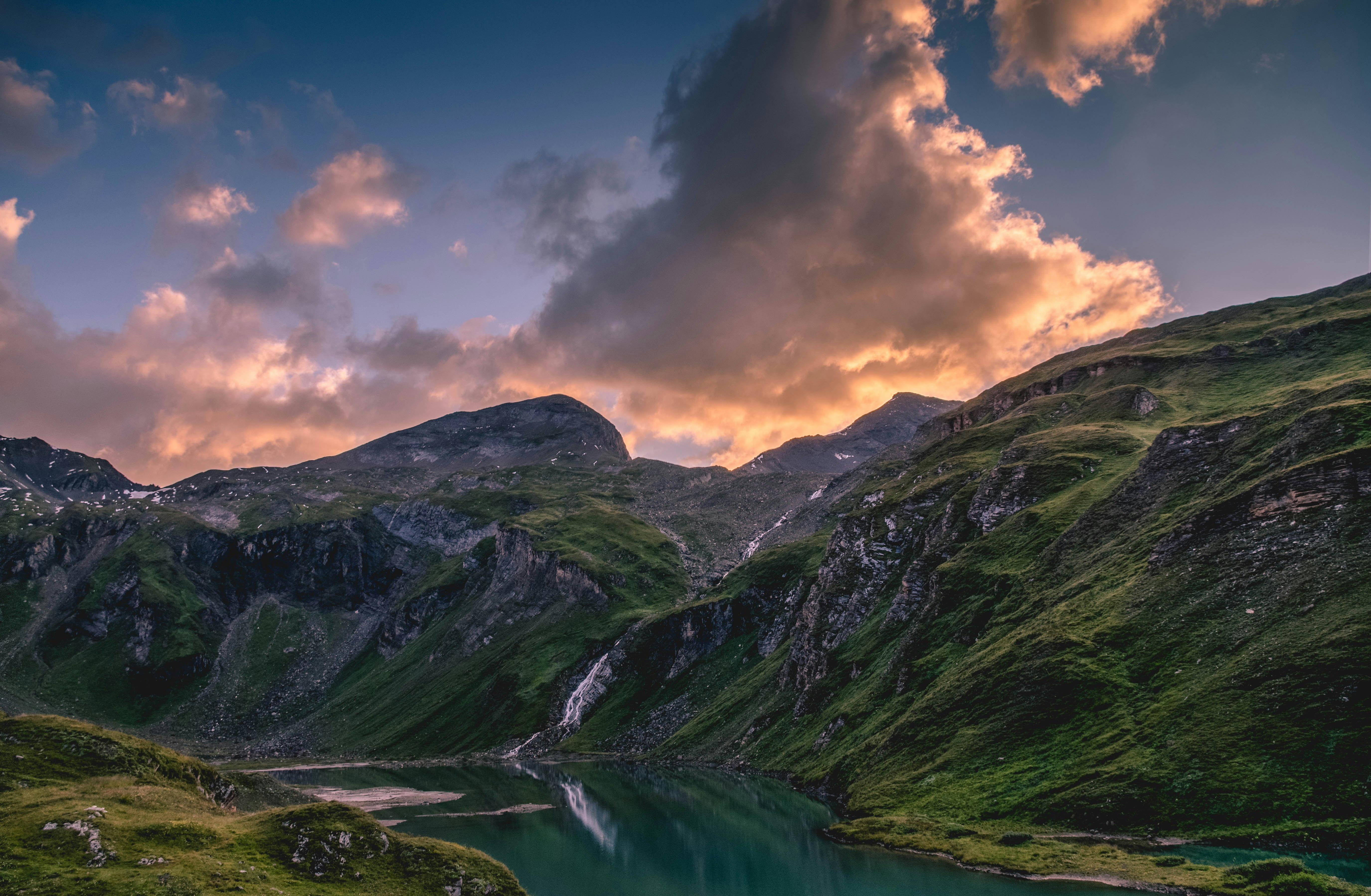 aerial view photography of river between mountain under commulus clouds